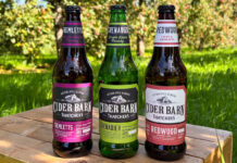 Thatchers expands Cider Barn range with a trio of new launches Thatchers Cider Barn bottles stand on a wooden crate in the middle of a grassy scene including Thatchers Redwood, Thatchers Grenadier and Thatchers Tremletts.