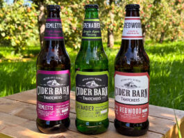 Thatchers expands Cider Barn range with a trio of new launches Thatchers Cider Barn bottles stand on a wooden crate in the middle of a grassy scene including Thatchers Redwood, Thatchers Grenadier and Thatchers Tremletts.