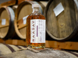 Isle of Raasay named World’s Best Scotch Whisky at Global Spirit Awards A bottle of Isle of Raasay whisky stands on top of a barrel in a warehouse with barrels in the background.