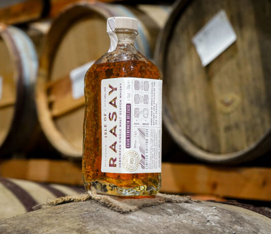 Isle of Raasay named World’s Best Scotch Whisky at Global Spirit Awards A bottle of Isle of Raasay whisky stands on top of a barrel in a warehouse with barrels in the background.
