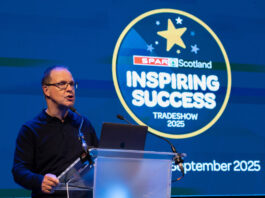Spar Scotland posts positive results amid turbulent trading period Colin McLean, chief executive at CJ Lang & Son, stands at a podium delivering a talk during the Spar Scotland Tradeshow 2025.