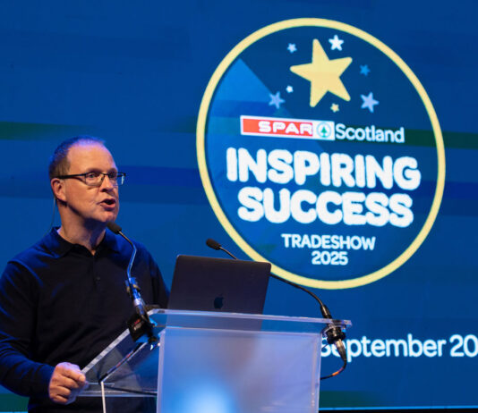 Spar Scotland posts positive results amid turbulent trading period Colin McLean, chief executive at CJ Lang & Son, stands at a podium delivering a talk during the Spar Scotland Tradeshow 2025.