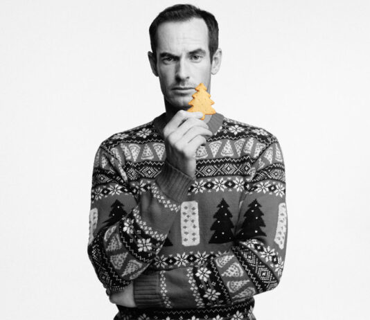 Walker’s Shortbread and Andy Murray knit in some festive cheer with Christmas jumper campaign Andy Murray stands holding a piece of Walker's Shortbread whilst wearing the Walker's Shortbread Christmas jumper in a black and white image.