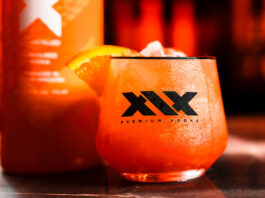 XIX Vodka expands distribution with Red Star Brands partnership A promotional image for the XIX Vodka brand with a cocktail serve in a XIX branded glass with a bottle of the vodka behind the glass.