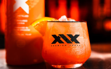 XIX Vodka expands distribution with Red Star Brands partnership A promotional image for the XIX Vodka brand with a cocktail serve in a XIX branded glass with a bottle of the vodka behind the glass.