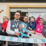 Co-op opens four new stores across Scotland A group of people open Co-op Selkirk using novelty scissors to cut a Co-op branded ribbon.