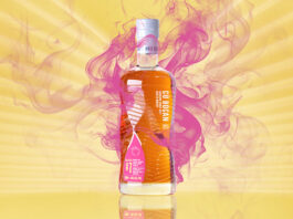 Cù Bòcan marks 20 years at Tomatin with new whisky A bottle of Cù Bòcan Creation #7 stands against a yellow background with lines of light coming from the centre and pink smoke behind the bottle.