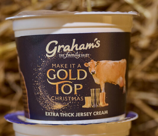Graham’s Gold Top Jersey Cream is back on the shelves A pack of Graham's Gold Top Extra Thick Jersey Cream stands on top of another pack in a barn with straw behind it.