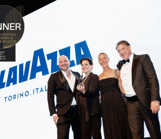 Lavazza named best Commercial Coffee Roaster for third year running A group of people accept the Best European Commercial Coffee Roaster award for Lavazza with the coffee brand's logo on the screen behind the group and the logo for the award in the corner.