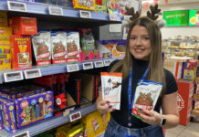 Scotmid scoops up Reindeer Poo treats from Shetland A woman wearing Reindeer antlers holds a pack of Puffin Poo and Reindeer Poo chocolates standing inside a Scotmid store.
