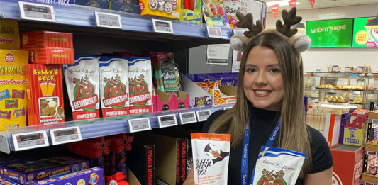 Scotmid scoops up Reindeer Poo treats from Shetland A woman wearing Reindeer antlers holds a pack of Puffin Poo and Reindeer Poo chocolates standing inside a Scotmid store.