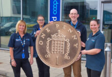 Scotmid rolls out Pennies round up for Alzheimer Scotland support Members of the Scotmid team stand together holding a novelty sized penny coin in front of the firm's headquarters.