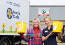 Spar Scotland hits record-breaking fundraising for charity Two staff members stands the Spar Scotland wholesale depot holding fundraising buckets for Marie Curie with the charity's branded van behind them.