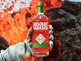 Absolut teams up with Tabasco hot sauce for spicy vodka launch A person holds a bottle of Absolut Tabasco Vodka with an insulated gloved hand against the background of an erupting volcano.
