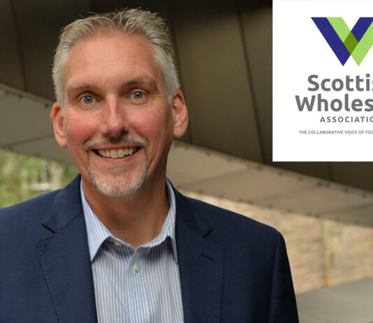 Scottish Wholesale Association unveils new website Colin Smith, chief executive at the Scottish Wholesale Association, with the logo for the organisation in the top right hand corner in a white box.