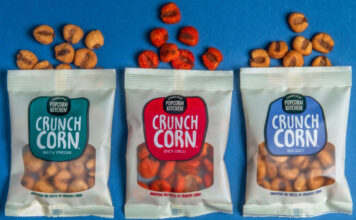 Popcorn Kitchen goes savoury with new Crunch Corn Pack of Popcorn Kitchen Crunch Corn lay open on a blue background with pieces of the corn spilled out from the top of the packs.