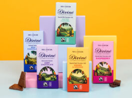 Divine Chocolate unveils refreshed new look Bars of Divine Chocolate with the 2026 redesign are stacked against boxes to showcase the new looks. There are pieces of chocolate next to the bars and the background is an orange colour with a blue foreground.