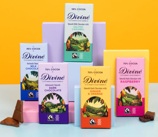 Divine Chocolate unveils refreshed new look Bars of Divine Chocolate with the 2026 redesign are stacked against boxes to showcase the new looks. There are pieces of chocolate next to the bars and the background is an orange colour with a blue foreground.
