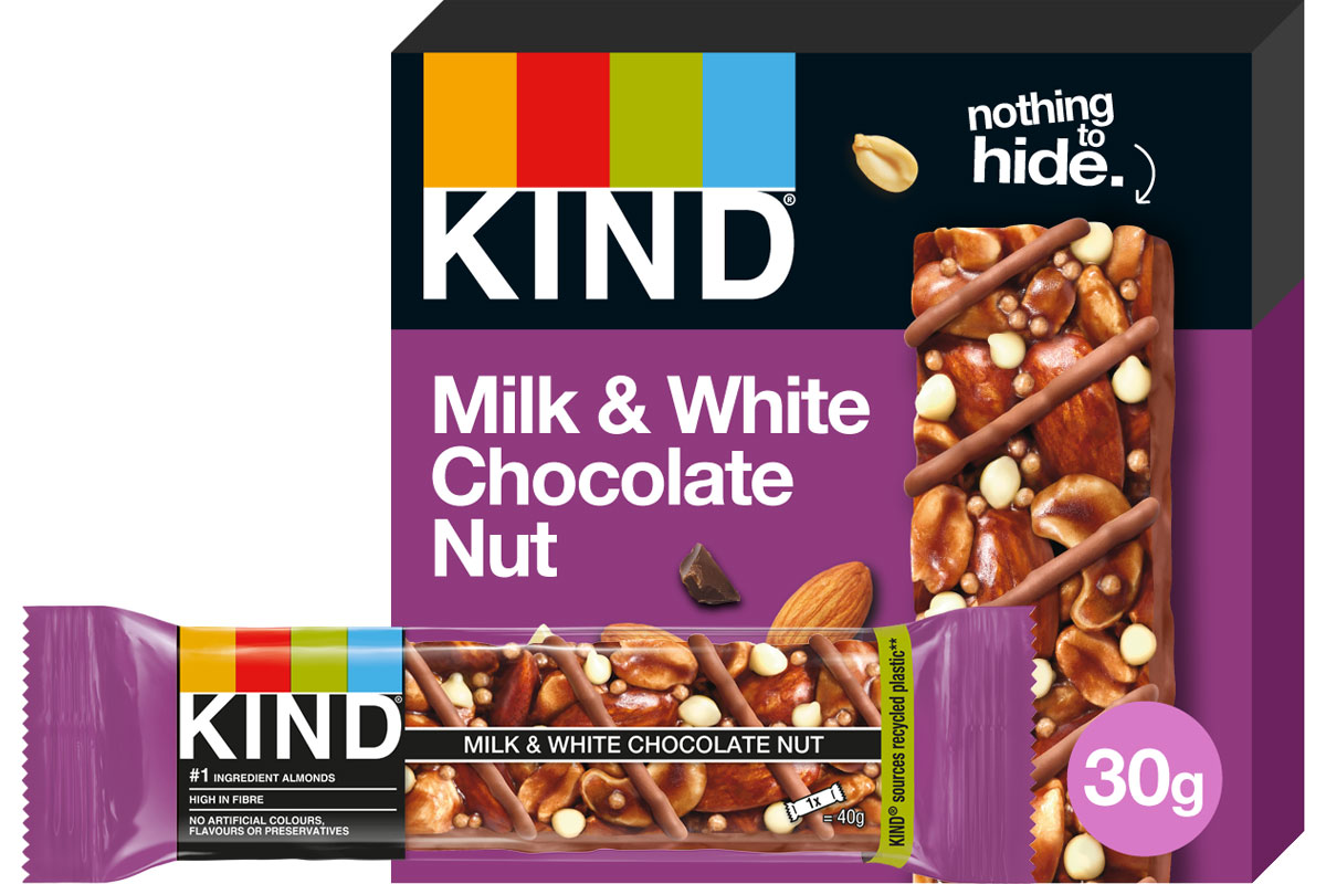 A pack of Kind Milk & White Chocolate Nut Bar stands in the background with a single bar of it in front of the pack.