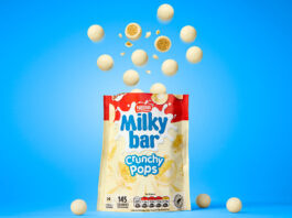 Milkybar drops in new Crunchy Pops treat A packet of Milkybar Crunchy Pops stands open against a blue background with pieces of the chocolate rising out of the top of the bag.