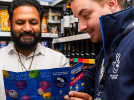 National Lottery retailers set new record for age-verification A representative of the National Lottery shows a retailers a pamphlet for the National Lottery inside his store.