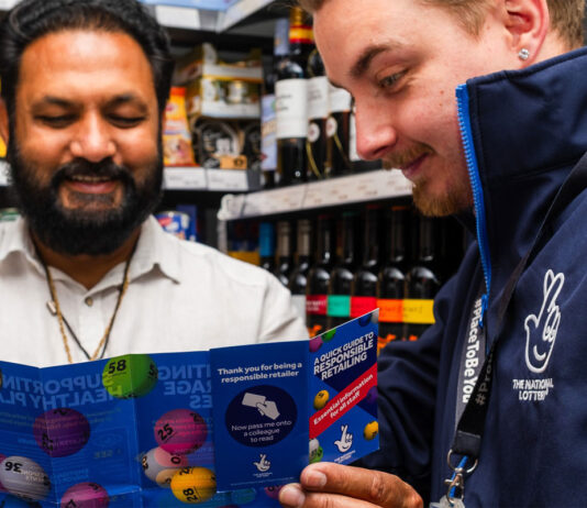 National Lottery retailers set new record for age-verification A representative of the National Lottery shows a retailers a pamphlet for the National Lottery inside his store.