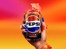 Pepsi Max adds in a Tropical flavour A person holds a can of Pepsi Max Tropical against a sunset background. The can has a cocktail umbrella sticking out of the top of it.