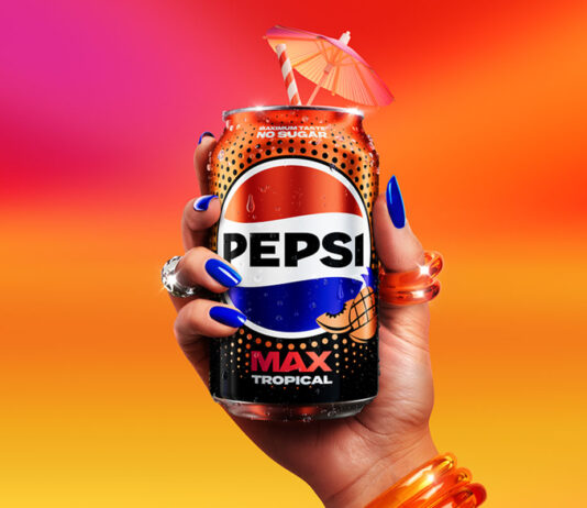 Pepsi Max adds in a Tropical flavour A person holds a can of Pepsi Max Tropical against a sunset background. The can has a cocktail umbrella sticking out of the top of it.