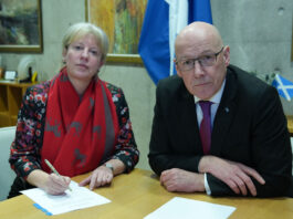 Scottish high streets are ‘one bad budget’ away from closing Shona Robison, finance secretary, and John Swinney, first minister, sit at a desk together with paper on the table and a saltire flag in the background.