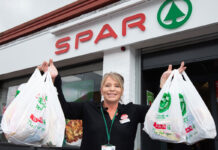 Spar saves shoppers cash with value deals push A woman holds two Spar branded shopping bags outside of a Spar store to highlights its value deals campaign for 2026.