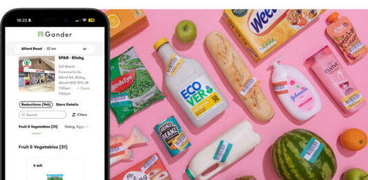 Gander integrates with ShopMate EPOS An iPhone shows the Gander app on its screen next to a range of products with reduced price labels across them.