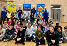 Healthy Living Programme and Scotmid feed over 650 pupils A group of children shout into a camera to mark Brain Health Week with banners for Scotmid Co-op and the Healthy Living Programme behind them.