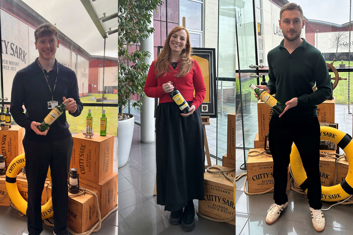 Team members from LMB UK hold bottles of Cutty Sark in the company's offices.