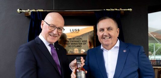 First Minister opens Luss Distillery First Minister John Swinney receives a bespoke bottle of whisky from Loch Lomond Group chief executive Colin Matthews.