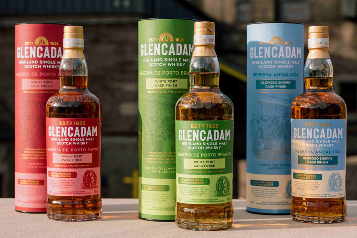 Bottles of Glencadam's new design along with their outer packs are lined up on a wall.