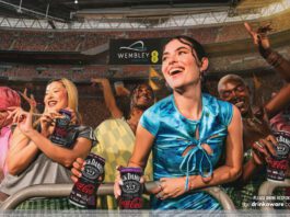 CCEP rolls out first on-pack promo for Jack Daniel’s & Coca-Cola A group of people are partying at Wembley Stadium in London holding cans of Jack Daniel's & Coca-Cola.
