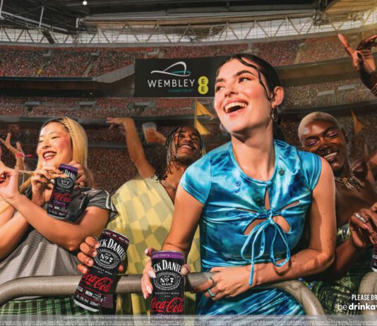 CCEP rolls out first on-pack promo for Jack Daniel’s & Coca-Cola A group of people are partying at Wembley Stadium in London holding cans of Jack Daniel's & Coca-Cola.