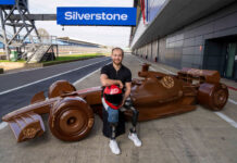 KitKat kicks off F1 season with life-sized chocolate car Billy Monger, former F1 driver, sits in front of a life-sized chocolate F1 car with the KitKat logo on it and the starting line of Silverstone Circuit.