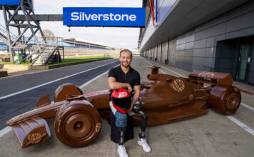 KitKat revs up for F1 season with life-sized chocolate car Billy Monger, former F1 driver, sits in front of a life-sized chocolate F1 car with the KitKat logo on it and the starting line of Silverstone Circuit.