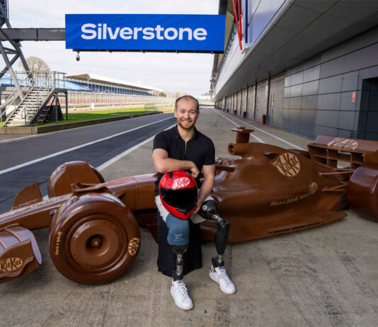 KitKat kicks off F1 season with life-sized chocolate car Billy Monger, former F1 driver, sits in front of a life-sized chocolate F1 car with the KitKat logo on it and the starting line of Silverstone Circuit.