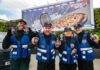 Pepsi Max launches multi-channel campaign A group of people stand in front of a billboard featuring the 2026 Pepsi Max campaign whilst holding cans of Pepsi Max.
