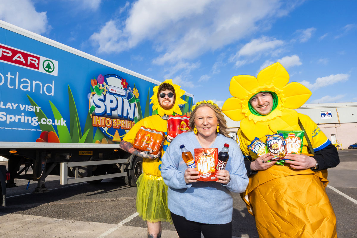 A group of Spar team members stand in front of a Spar lorry with livery for the Spin into Spring activation across it.