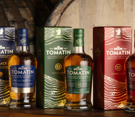 Tomatin showcases striking new packaging Bottles of Tomatin featuring the 2026 redesign with whisky casks behind the bottles.