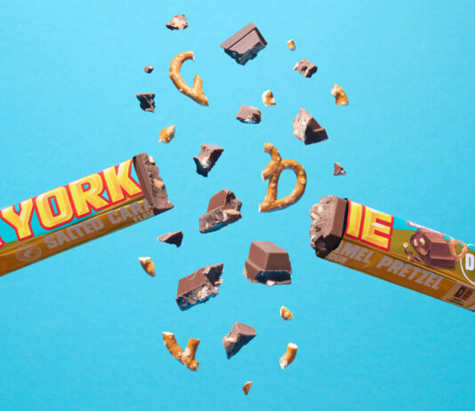 Yorkie unveils new Salted Caramel Pretzel bar A Yorkie Salted Caramel Pretzel bar is broken in two with pieces flying out from it against a blue background.