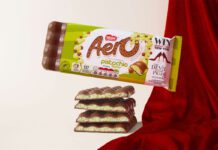 Aero takes to the runway with new Pistachio flavour A pack of Aero Pistachio is balanced on top of bars of the chocolate with a red fabric draped behind it.