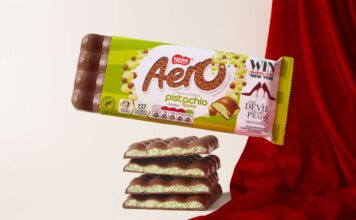Aero takes to the runway with new Pistachio flavour A pack of Aero Pistachio is balanced on top of bars of the chocolate with a red fabric draped behind it.