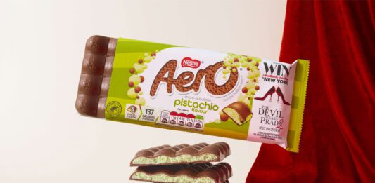 Aero takes to the runway with new Pistachio flavour A pack of Aero Pistachio is balanced on top of bars of the chocolate with a red fabric draped behind it.