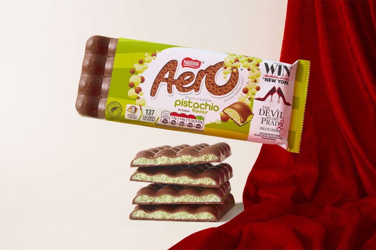 A pack of Aero Pistachio is balanced on top of bars of the chocolate with a red fabric draped behind it.