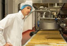Andy Murray makes a visit to Walker’s Shortbread factory Andy Murray stands over a conveyer belt with shortbread on it.