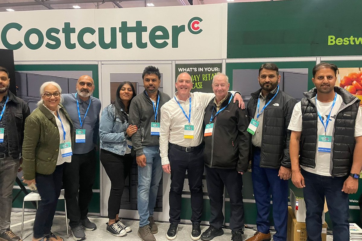 A group of people stand outside a mock Costcutter shop at the Bestway Retail Showcase.
